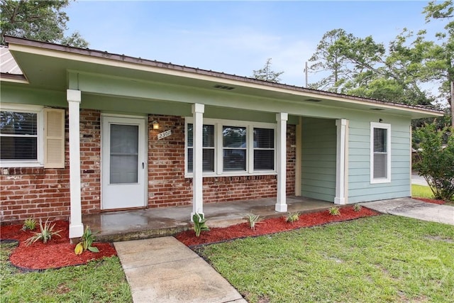 2301 Pinetree Rd, Savannah, GA 31404 - view of front of home featuring covered porch, a front lawn, metal roof, and brick siding