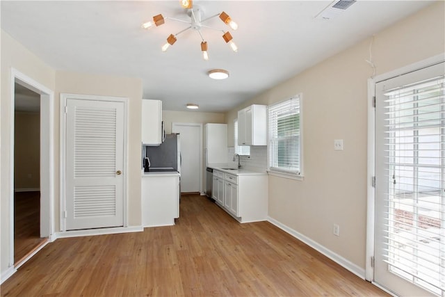 2301 Pinetree Rd, Savannah, GA 31404 - kitchen with a sink, light wood finished floors, white cabinetry, and light countertops