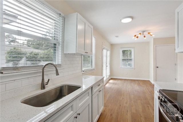 2301 Pinetree Rd, Savannah, GA 31404 - kitchen with a sink, tasteful backsplash, baseboards, light wood finished floors, and white cabinets