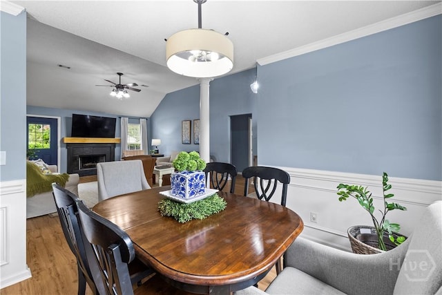 267 Jasper Ln, Rincon, GA 31326 - dining space with light wood-style floors, a fireplace, ceiling fan, vaulted ceiling, and a wainscoted wall