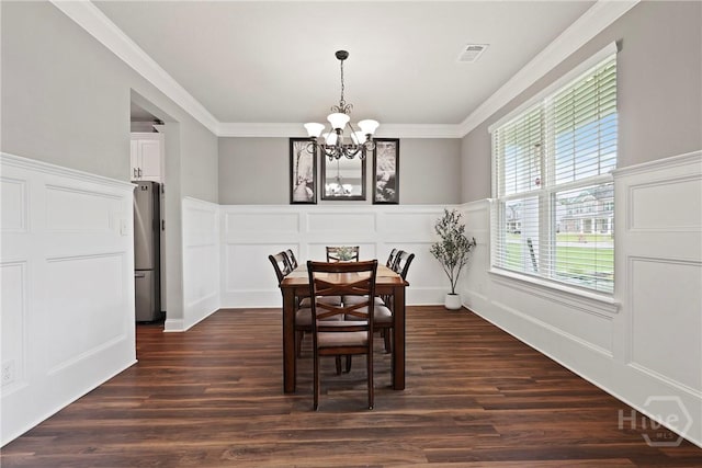 108 Summer Station Dr, Guyton, GA 31312 - dining room featuring a chandelier, a decorative wall, dark wood finished floors, crown molding, and a wainscoted wall