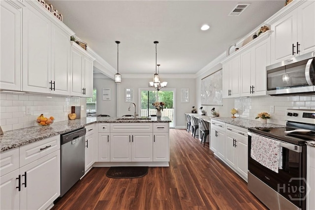 108 Summer Station Dr, Guyton, GA 31312 - kitchen featuring stainless steel appliances, a peninsula, dark wood-style flooring, ornamental molding, and white cabinets