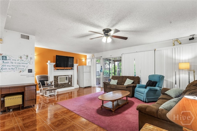 114 Piercefield Dr, Richmond Hill, GA 31324 - living area with a ceiling fan, a glass covered fireplace, a textured ceiling, and tile patterned floors