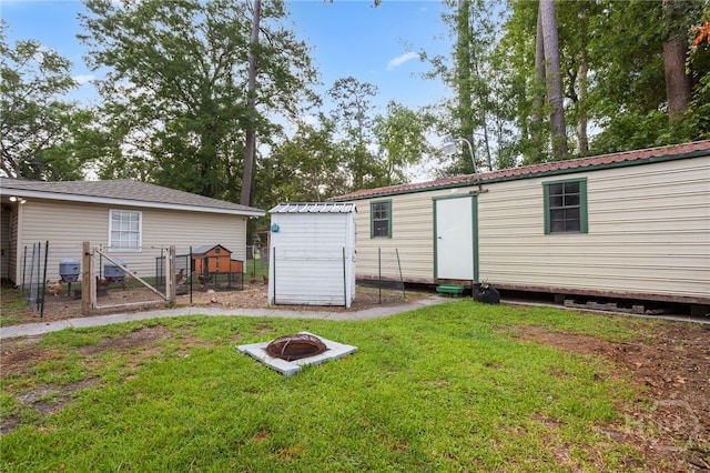 114 Piercefield Dr, Richmond Hill, GA 31324 - back of property featuring an outdoor fire pit and a storage unit