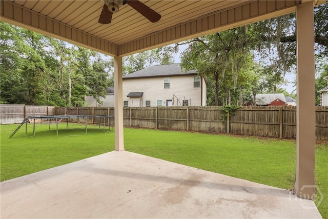 93 Veranda Trl, Midway, GA 31320 - fenced backyard with a ceiling fan, a patio, and a trampoline