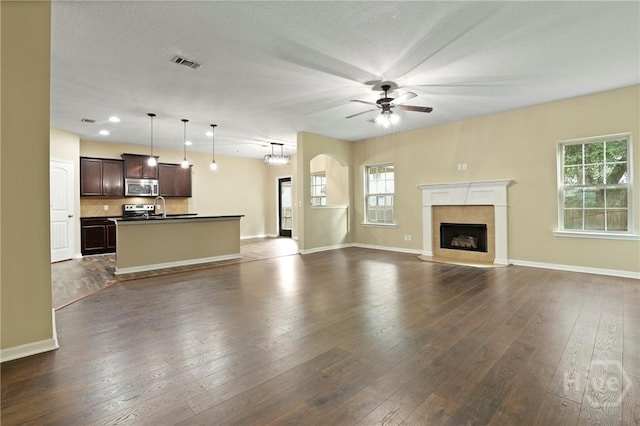 93 Veranda Trl, Midway, GA 31320 - unfurnished living room with a ceiling fan, plenty of natural light, baseboards, and dark wood-style flooring