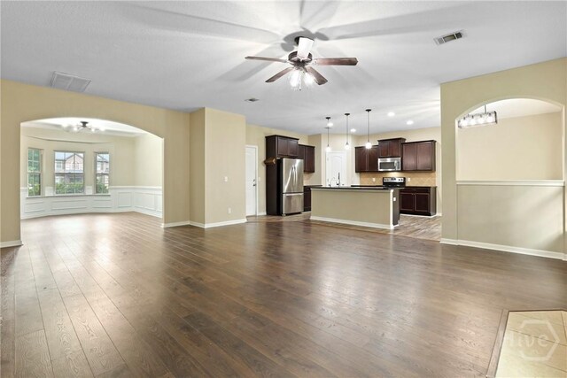 93 Veranda Trl, Midway, GA 31320 - unfurnished living room featuring a ceiling fan, arched walkways, and dark wood-type flooring