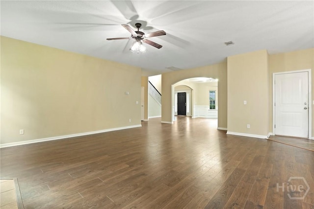 93 Veranda Trl, Midway, GA 31320 - unfurnished living room featuring arched walkways, a ceiling fan, dark wood finished floors, and baseboards