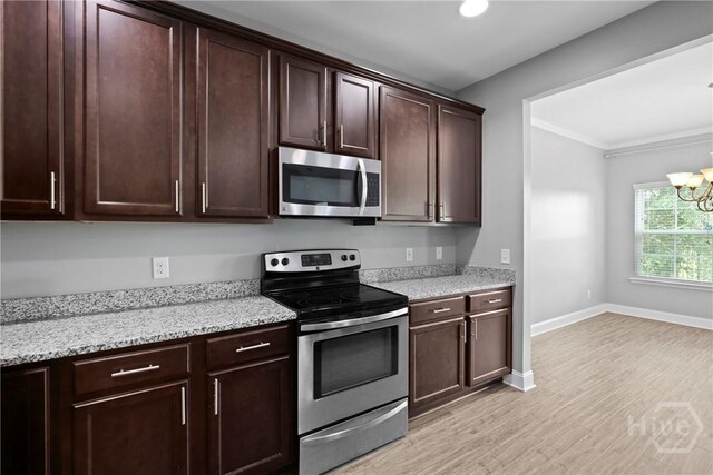 7 Sailmaker Ln, Richmond Hill, GA 31324 - kitchen with stainless steel appliances, light wood-type flooring, a chandelier, dark brown cabinetry, and light stone countertops