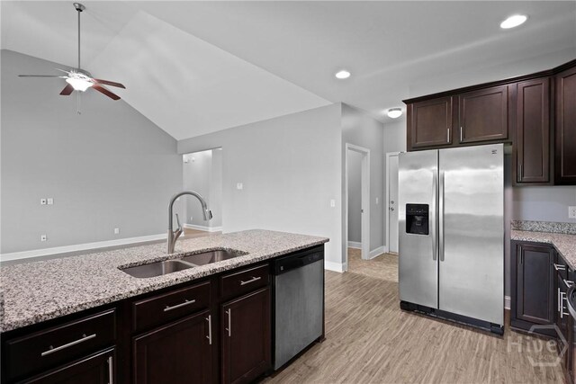 7 Sailmaker Ln, Richmond Hill, GA 31324 - kitchen featuring stainless steel appliances, a sink, a ceiling fan, light stone countertops, and light wood finished floors