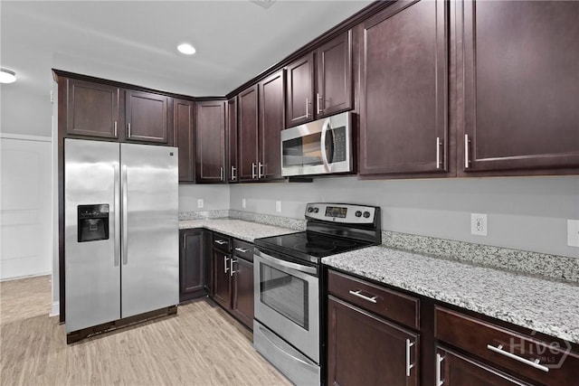 7 Sailmaker Ln, Richmond Hill, GA 31324 - kitchen featuring stainless steel appliances, light stone countertops, light wood-style flooring, dark brown cabinetry, and recessed lighting