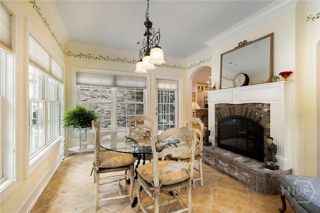 10 Cedar View Dr, Savannah, GA 31410 - dining space featuring arched walkways, a chandelier, light tile patterned floors, a brick fireplace, and crown molding