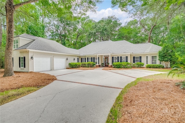 14 Black Hawk Trl, Savannah, GA 31411 - view of front of house featuring stucco siding, concrete driveway, a garage, and roof with shingles