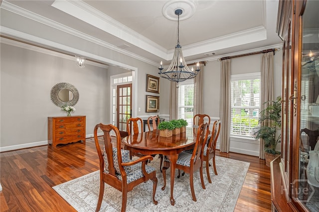 14 Black Hawk Trl, Savannah, GA 31411 - dining space featuring a chandelier, wood finished floors, a raised ceiling, crown molding, and baseboards