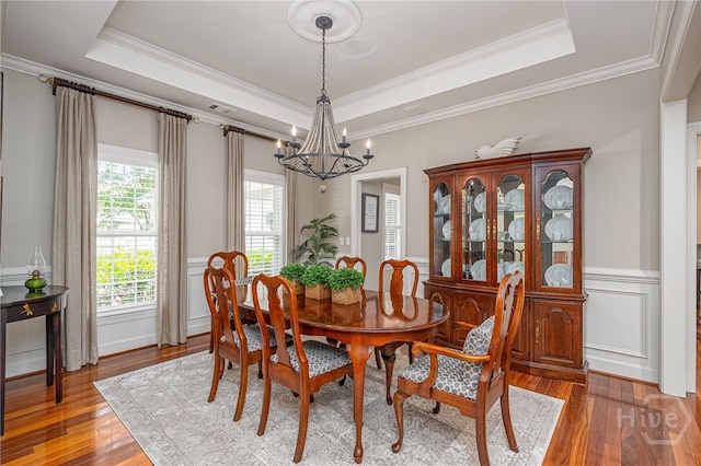 14 Black Hawk Trl, Savannah, GA 31411 - dining area with a chandelier, wood finished floors, a tray ceiling, ornamental molding, and a wainscoted wall