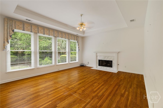 35 Wild Thistle Ln, Savannah, GA 31406 - unfurnished living room featuring a tray ceiling, wood finished floors, ceiling fan, baseboards, and ornamental molding