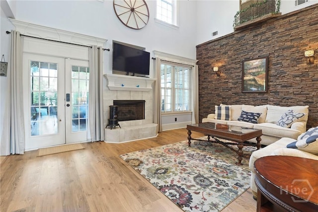 711 Chastain Cir, Richmond Hill, GA 31324 - living room with french doors, wood finished floors, a towering ceiling, and a tile fireplace