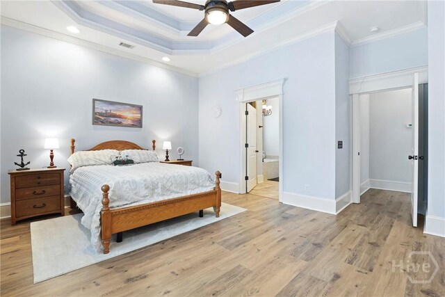 711 Chastain Cir, Richmond Hill, GA 31324 - bedroom featuring light wood-style flooring, ornamental molding, a raised ceiling, baseboards, and connected bathroom