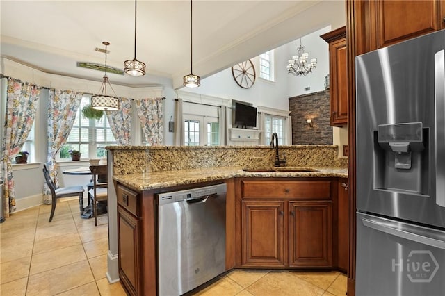 711 Chastain Cir, Richmond Hill, GA 31324 - kitchen with appliances with stainless steel finishes, a peninsula, a sink, light tile patterned floors, and plenty of natural light