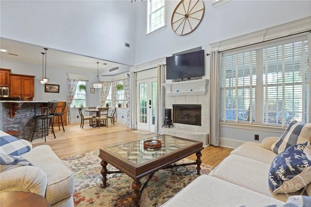 711 Chastain Cir, Richmond Hill, GA 31324 - living area featuring healthy amount of natural light, light wood finished floors, a fireplace, baseboards, and a towering ceiling