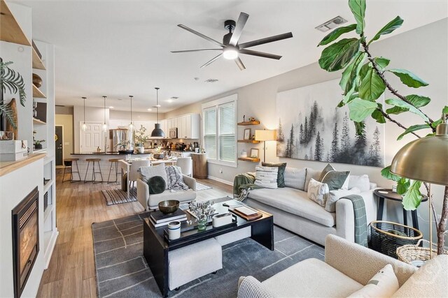 131 Tanzania Trl, Pooler, GA 31322 - living area with light wood-style floors, ceiling fan, a fireplace, and baseboards