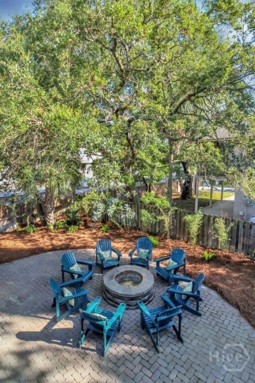 16 12th St, Tybee Island, GA 31328 - fenced backyard featuring an outdoor fire pit and a patio area