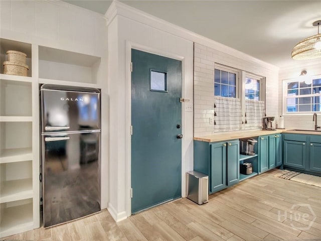 16 12th St, Tybee Island, GA 31328 - kitchen with wood counters, ornamental molding, light wood-style flooring, open shelves, and a sink