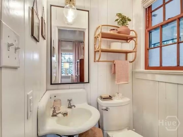 16 12th St, Tybee Island, GA 31328 - bathroom featuring a decorative wall, toilet, and a sink