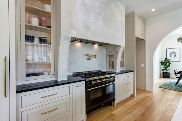 217 John Wesley Way, Savannah, GA 31404 - kitchen with range with two ovens, arched walkways, tasteful backsplash, dark countertops, and recessed lighting