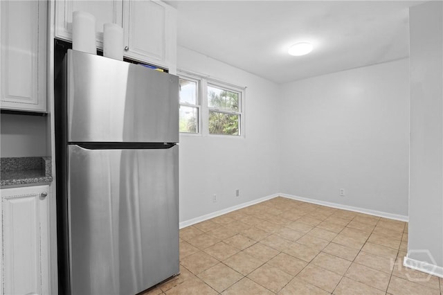 2030 E 42nd St, Savannah, GA 31404 - kitchen featuring freestanding refrigerator, white cabinets, baseboards, and light tile patterned flooring