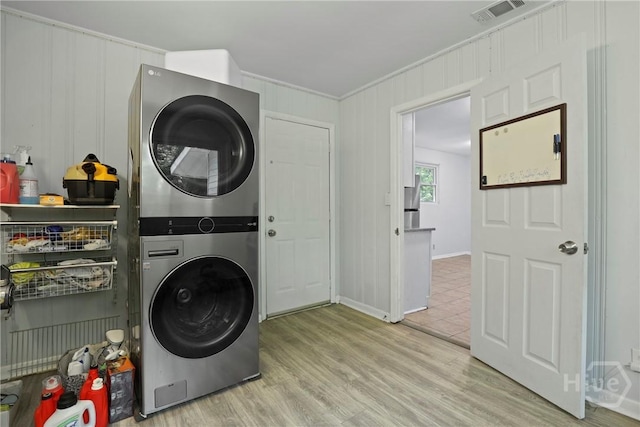 2030 E 42nd St, Savannah, GA 31404 - laundry room with stacked washer and clothes dryer, ornamental molding, wood finished floors, and baseboards