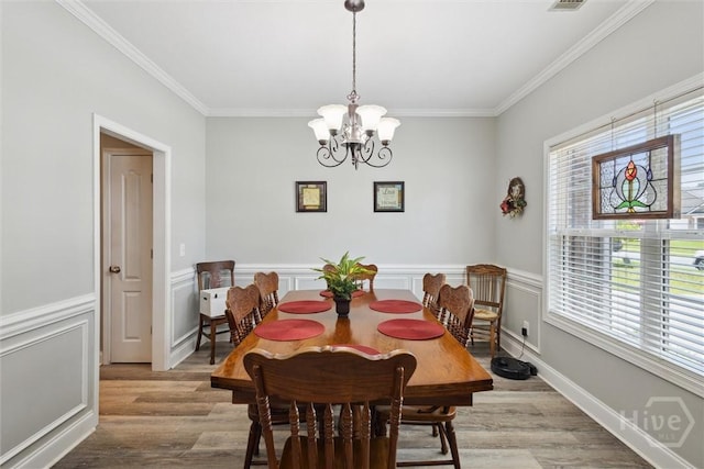 133 Cobbleton Dr, Rincon, GA 31326 - dining area featuring crown molding, light wood-style floors, plenty of natural light, a chandelier, and wainscoting