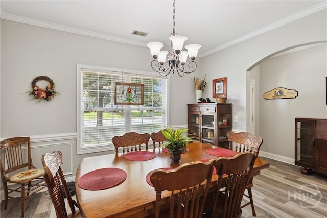133 Cobbleton Dr, Rincon, GA 31326 - dining room with arched walkways, light wood finished floors, ornamental molding, and a chandelier