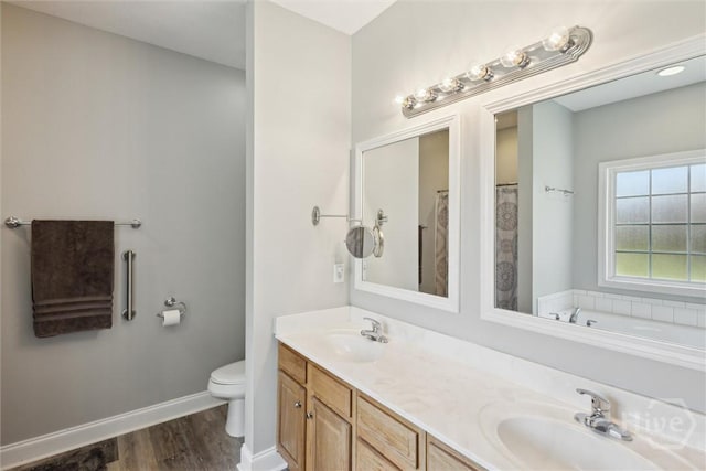 133 Cobbleton Dr, Rincon, GA 31326 - bathroom with wood finished floors, double vanity, toilet, baseboards, and a bathtub