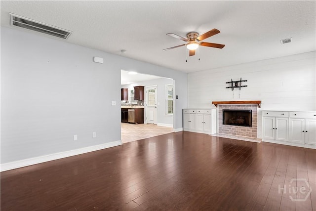 42 Kinlock Ct, Midway, GA 31320 - unfurnished living room with ceiling fan, a brick fireplace, light wood finished floors, and baseboards