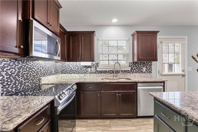 42 Kinlock Ct, Midway, GA 31320 - kitchen with stainless steel appliances, a sink, decorative backsplash, light stone counters, and a textured ceiling