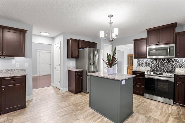 42 Kinlock Ct, Midway, GA 31320 - kitchen featuring stainless steel appliances, tasteful backsplash, a chandelier, a kitchen island, and dark brown cabinets
