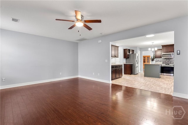 42 Kinlock Ct, Midway, GA 31320 - unfurnished living room with light wood finished floors, a chandelier, a ceiling fan, and baseboards