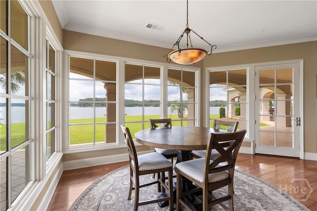 745 S Chickasaw Trl, Sparta, GA 31087 - dining area featuring a water view, baseboards, wood-type flooring, and ornamental molding