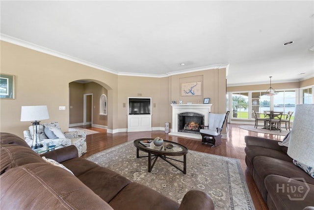 745 S Chickasaw Trl, Sparta, GA 31087 - living area with wood finished floors, arched walkways, crown molding, a warm lit fireplace, and baseboards