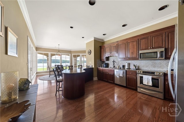 745 S Chickasaw Trl, Sparta, GA 31087 - kitchen with stainless steel appliances, dark wood-type flooring, tasteful backsplash, a kitchen breakfast bar, and crown molding