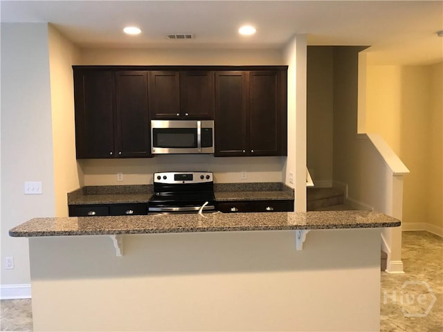 60 Kepler Loop, Richmond Hill, GA 31324 - kitchen with stainless steel appliances, a kitchen breakfast bar, dark stone countertops, and recessed lighting