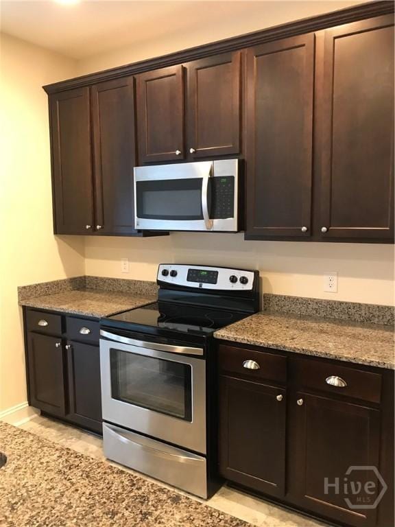 60 Kepler Loop, Richmond Hill, GA 31324 - kitchen featuring appliances with stainless steel finishes, dark brown cabinets, and baseboards