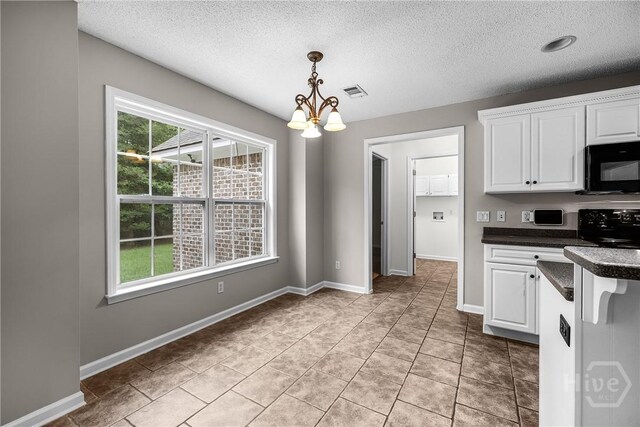 172 Jamestown Dr, Rincon, GA 31326 - kitchen featuring black microwave, dark countertops, a textured ceiling, white cabinetry, and hanging light fixtures