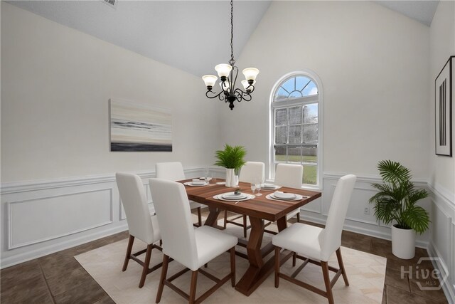 172 Jamestown Dr, Rincon, GA 31326 - dining space with a decorative wall, a chandelier, vaulted ceiling, light tile patterned flooring, and wainscoting