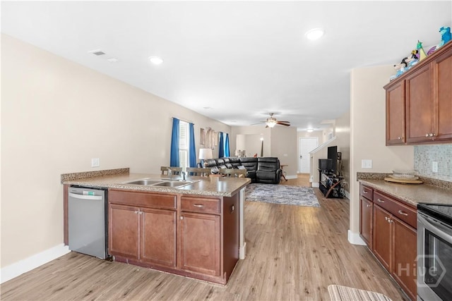 135 Verde Bnd, Savannah, GA 31419 - kitchen with appliances with stainless steel finishes, a peninsula, a sink, light wood finished floors, and brown cabinets