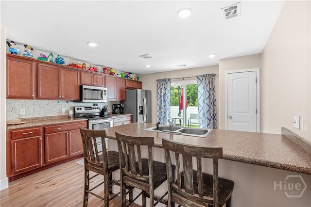 135 Verde Bnd, Savannah, GA 31419 - kitchen featuring stainless steel appliances, a kitchen breakfast bar, light wood-style floors, a sink, and a peninsula