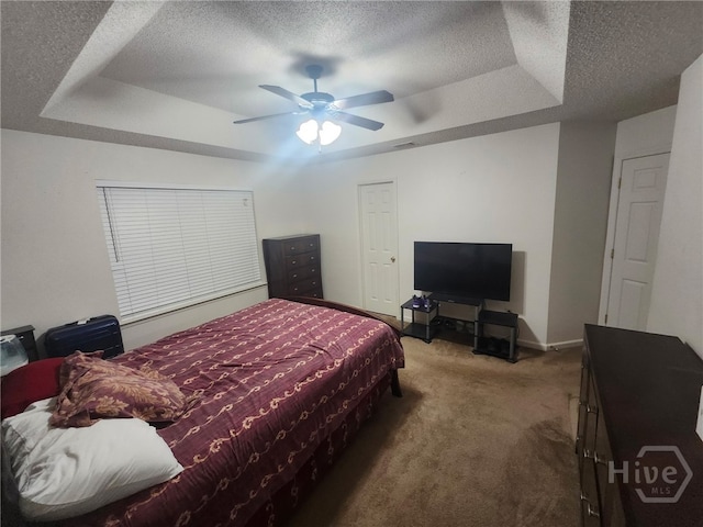 182 Gloucester Dr, Midway, GA 31320 - carpeted bedroom featuring a tray ceiling, a textured ceiling, and ceiling fan