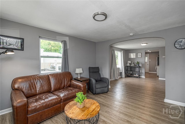 1515 Vine St, Savannah, GA 31401 - living room with arched walkways, baseboards, light wood-style floors, and a textured ceiling