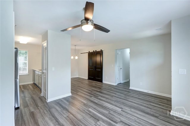 106 Oyster Catcher Ln, Savannah, GA 31410 - unfurnished room with a barn door, dark wood finished floors, baseboards, and ceiling fan